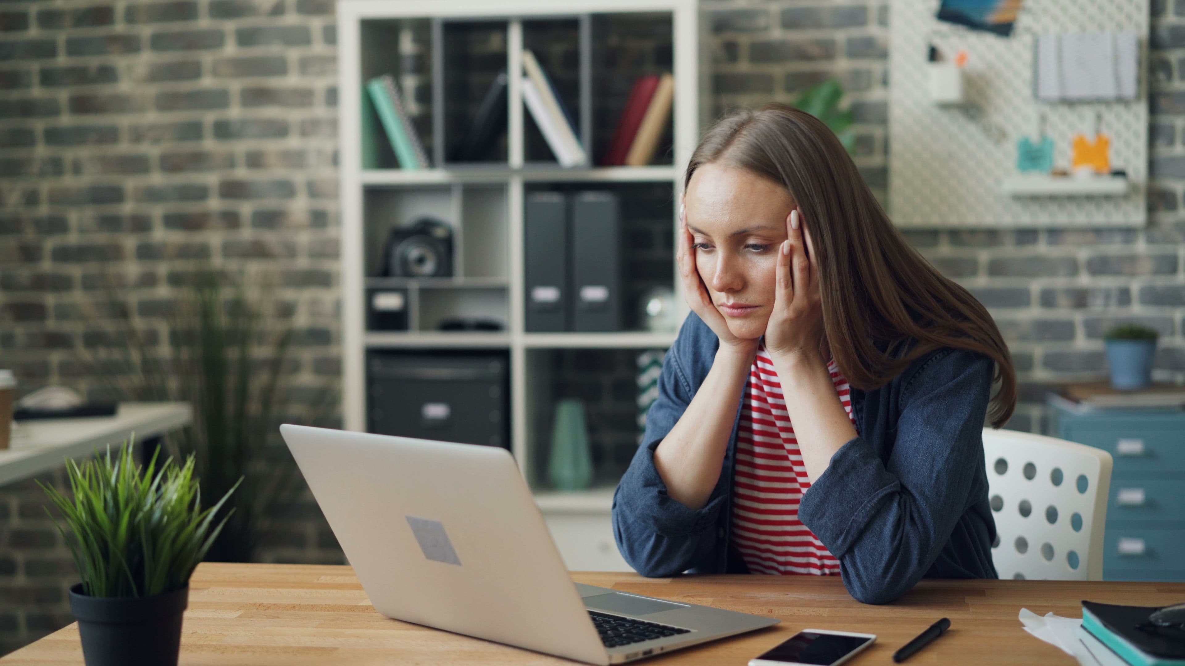 Overwhelmed marketer staring at a laptop